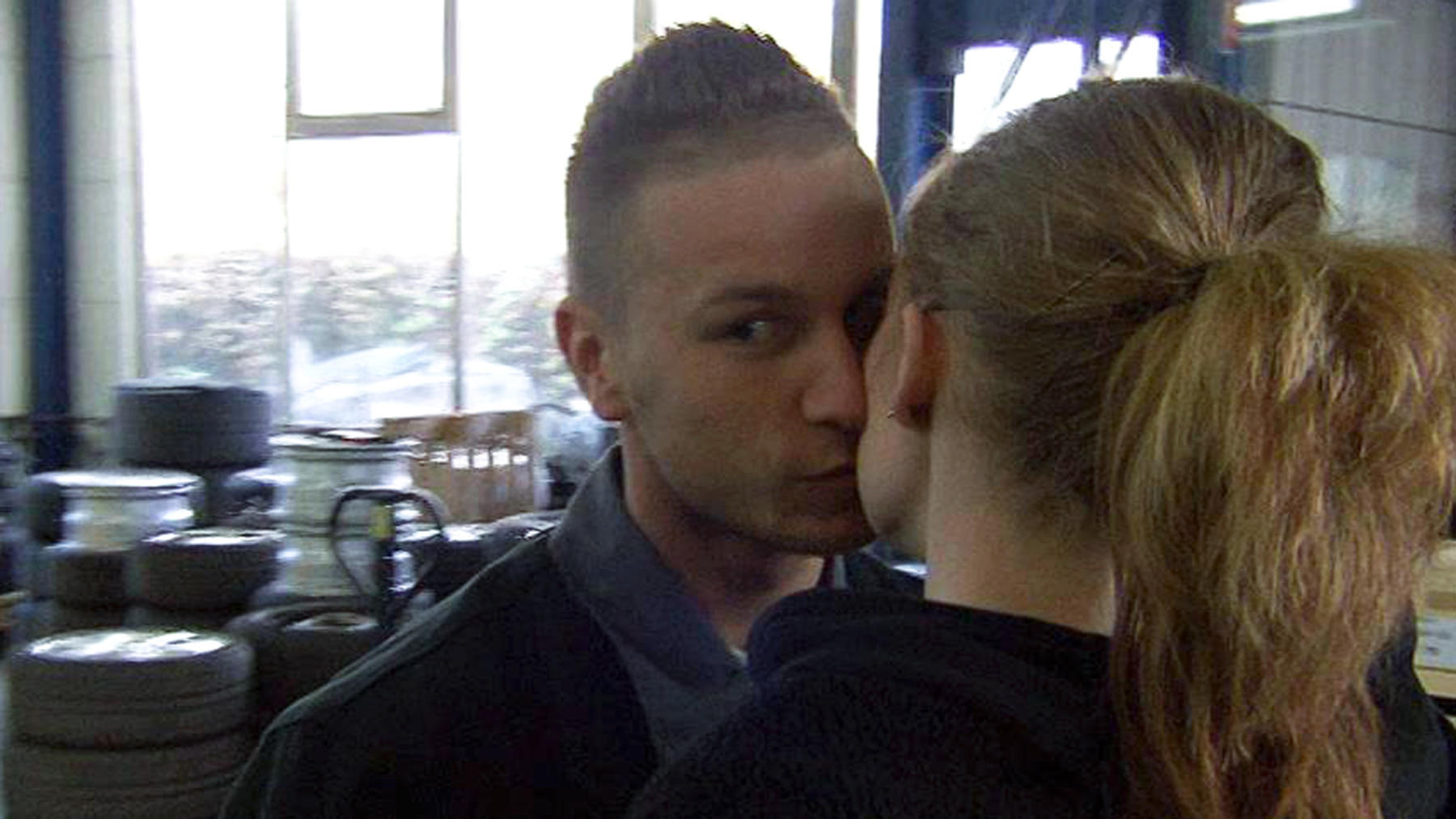 Autolackierer küsst Freundin immer mit offenen Augen